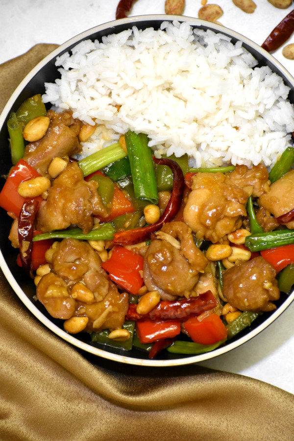kung pao chicken in a black bowl with rice