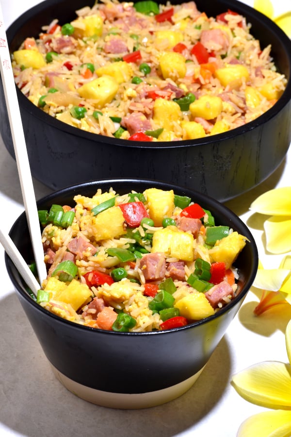 Dos cuencos negros llenos de este arroz frito al estilo hawaiano.