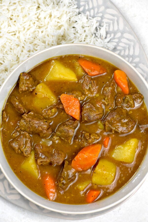 Bowl of Japanese beef curry alongside a platter of rice.