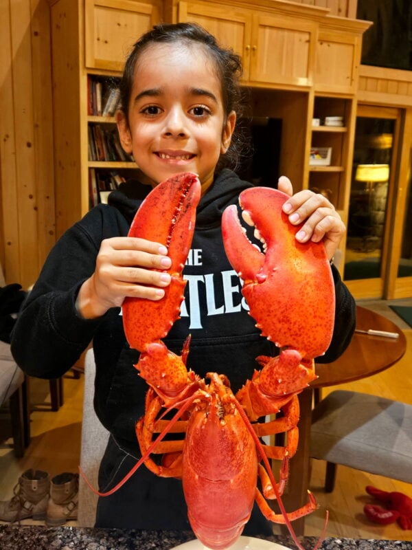 Noah holding up the cooked lobster