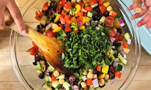 Tossing the vegetables and herbs in a large bowl.