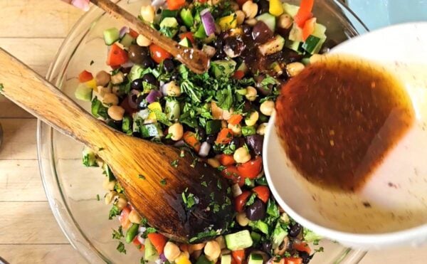 Pouring dressing on the salad.