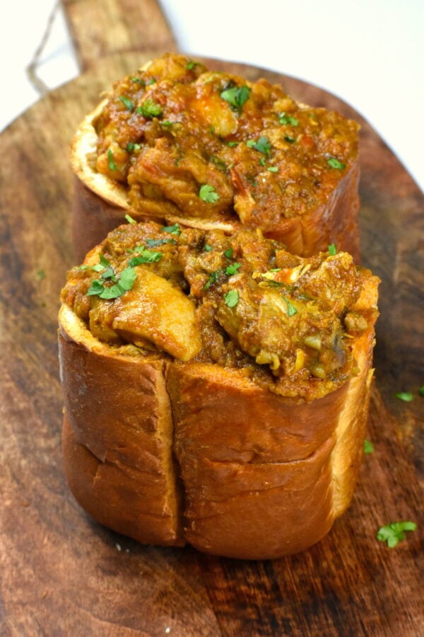 Two hollowed out bread halves filled with curry.