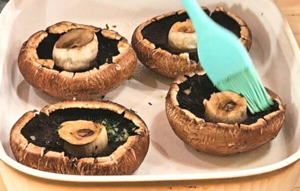 Brushing the mushrooms with garlic butter.