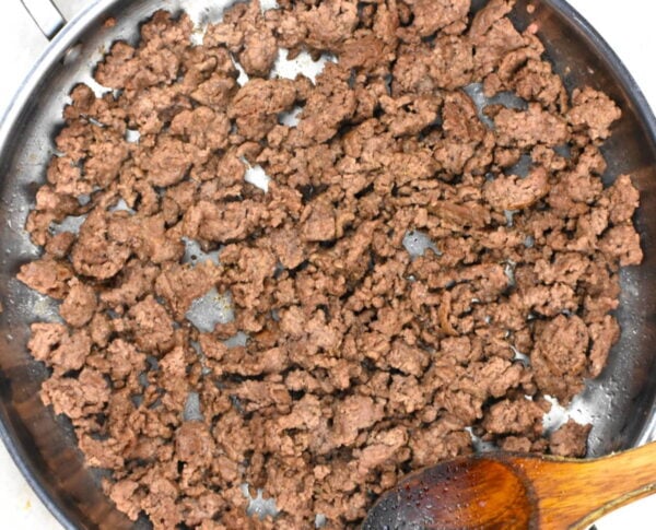 Ground beef browning in a skillet.