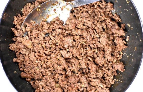 Ground beef browning in a pan.