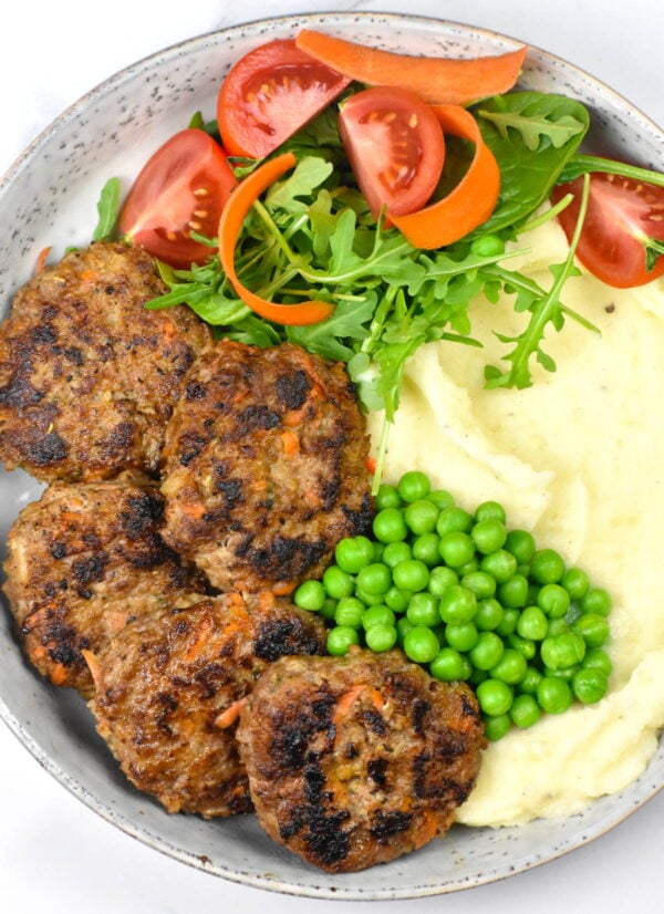 Beef rissoles served with mashed potatoes and veggies.