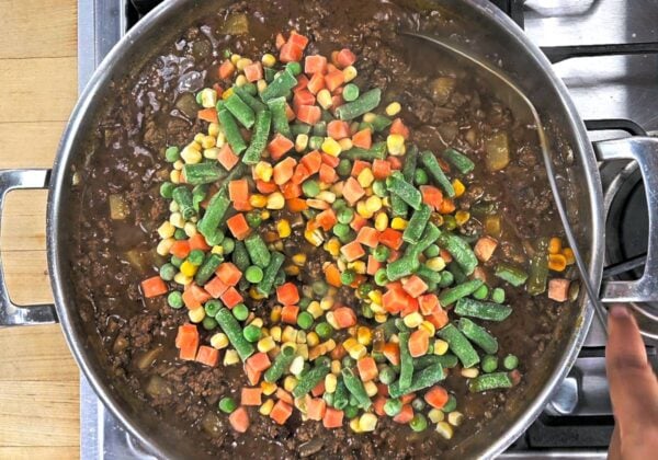 Adding frozen vegetables.