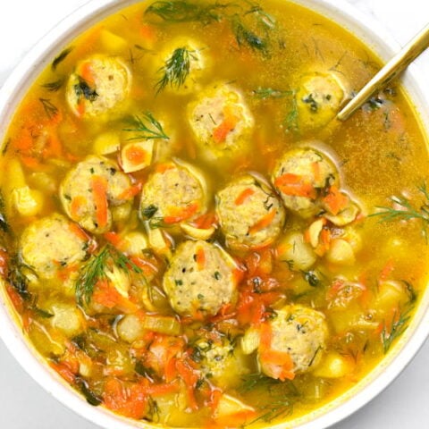 Frikadelki soup in a white bowl.