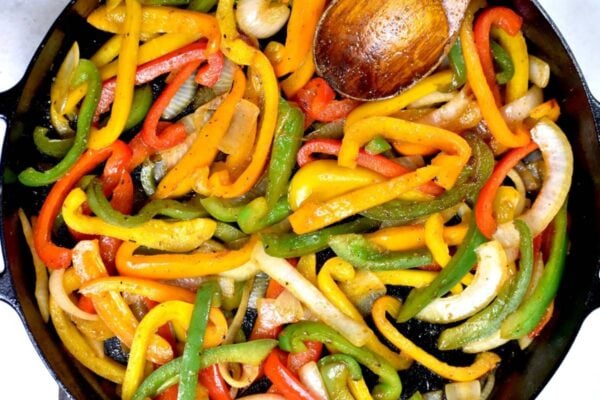cooking the sliced onion and peppers in a cast iron skillet.
