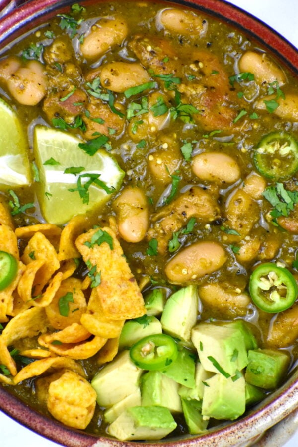 Green chili served with avocado and frito chips.