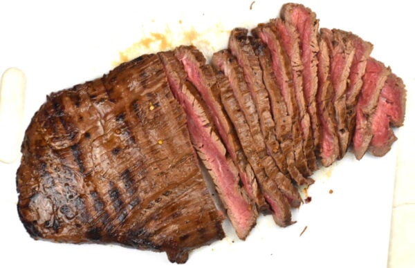 Sliced flank steak on a cutting board.