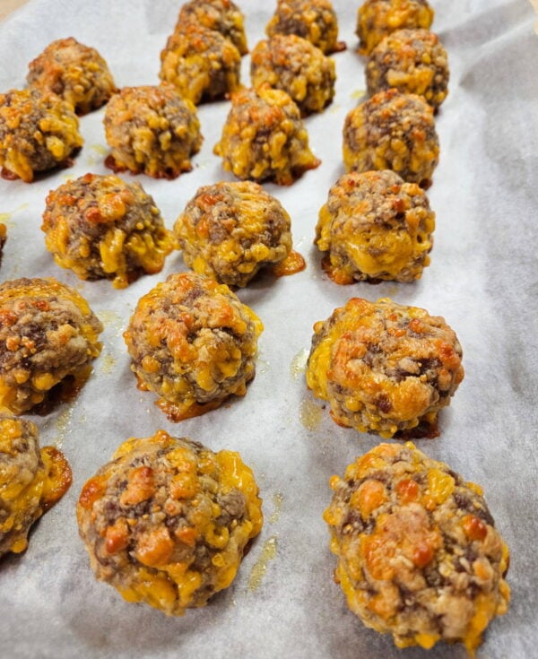 Sausage balls on a baking sheet after cooking.