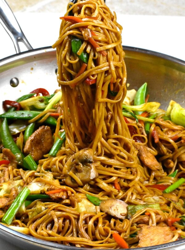 scooping up some noodles with tongs