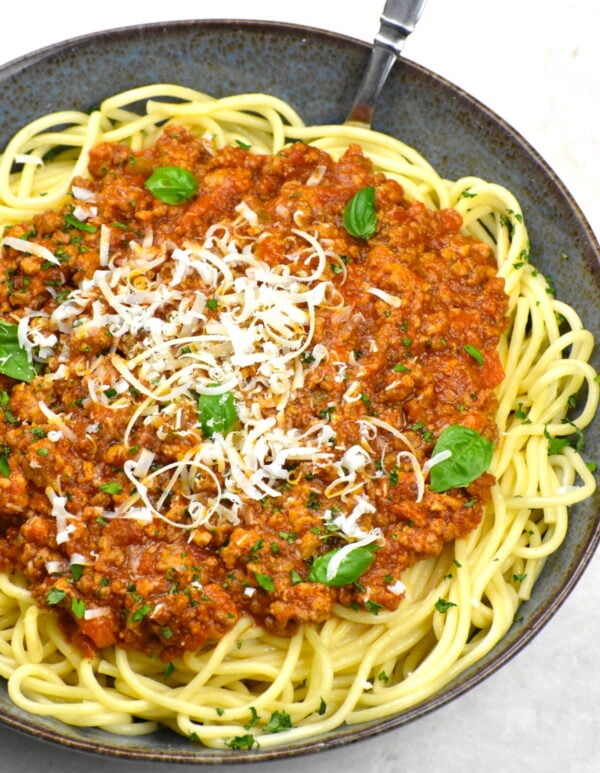 cooked spaghetti topped with bolognese sauce