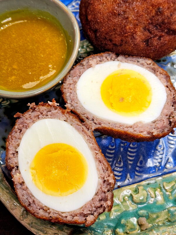 serving a halved scotch egg with honey mustard sauce