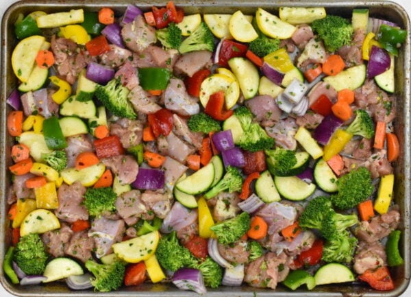marinated chicken and veggies on sheet pan prior to baking.