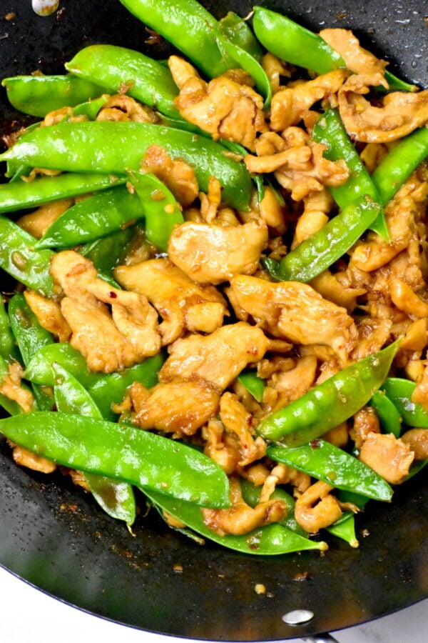 Chicken with snow peas in a wok.