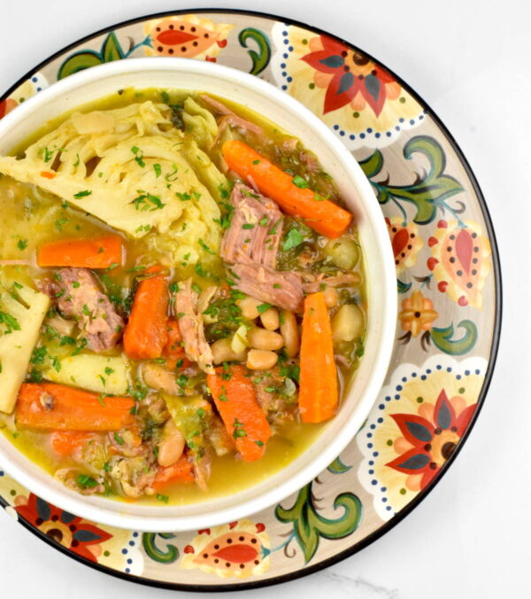 Bowl of garbure atop the Gypsy Plate.