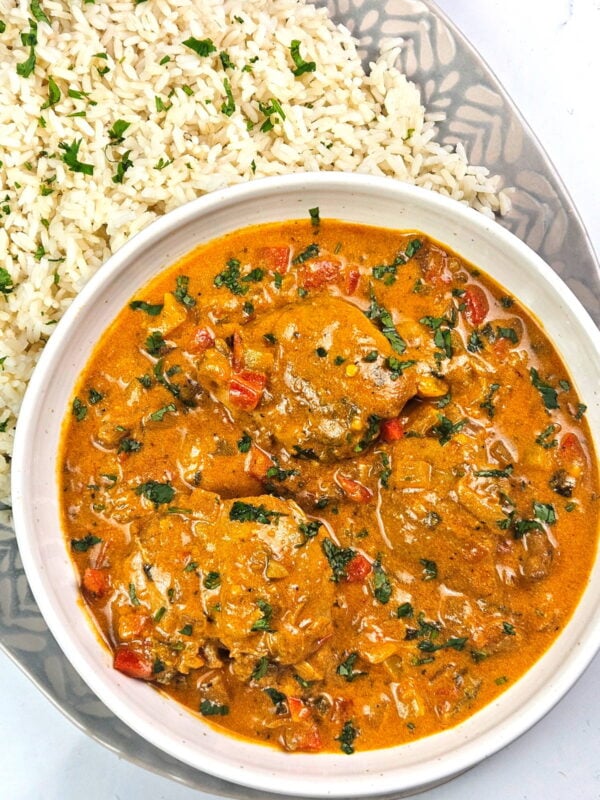 Brazilian coconut chicken in a bowl alongside rice.
