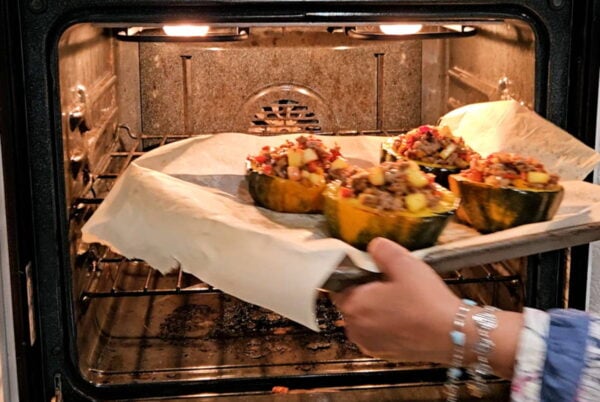 Placing the filled squash in the oven.