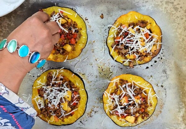 Garnishing the sausage stuffed squash with parm.