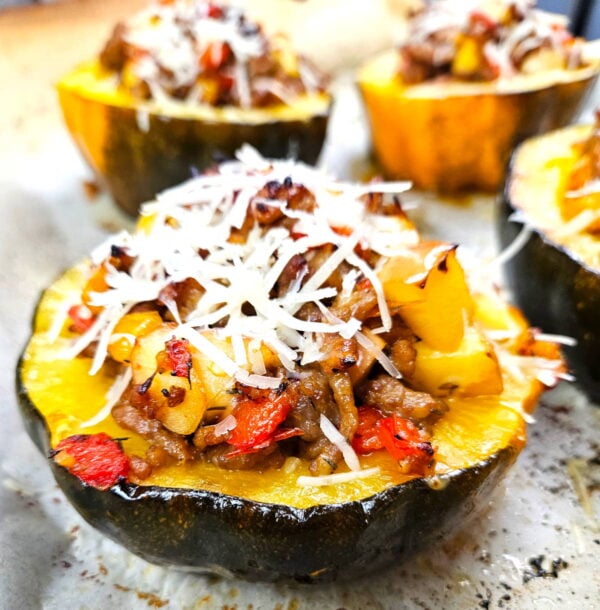 Half of an acorn squash stuffed with sausage and topped with parmesan cheese.