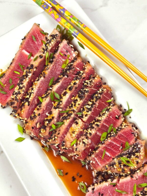 Sesame crusted tuna steaks on a platter.